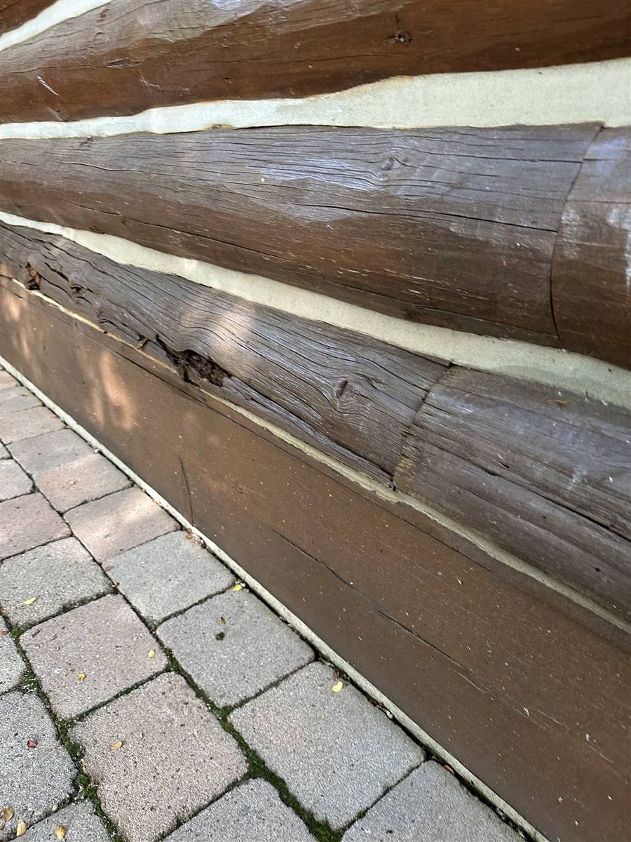 Chinking lines running between stained logs on an Idaho log home wall
