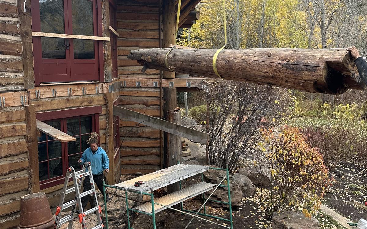 Crane lifting a replacement log into place on a log home job site near Sun Valley, Idaho